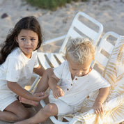 kids wearing wearing cream jumpsuit and tee with palm tree print