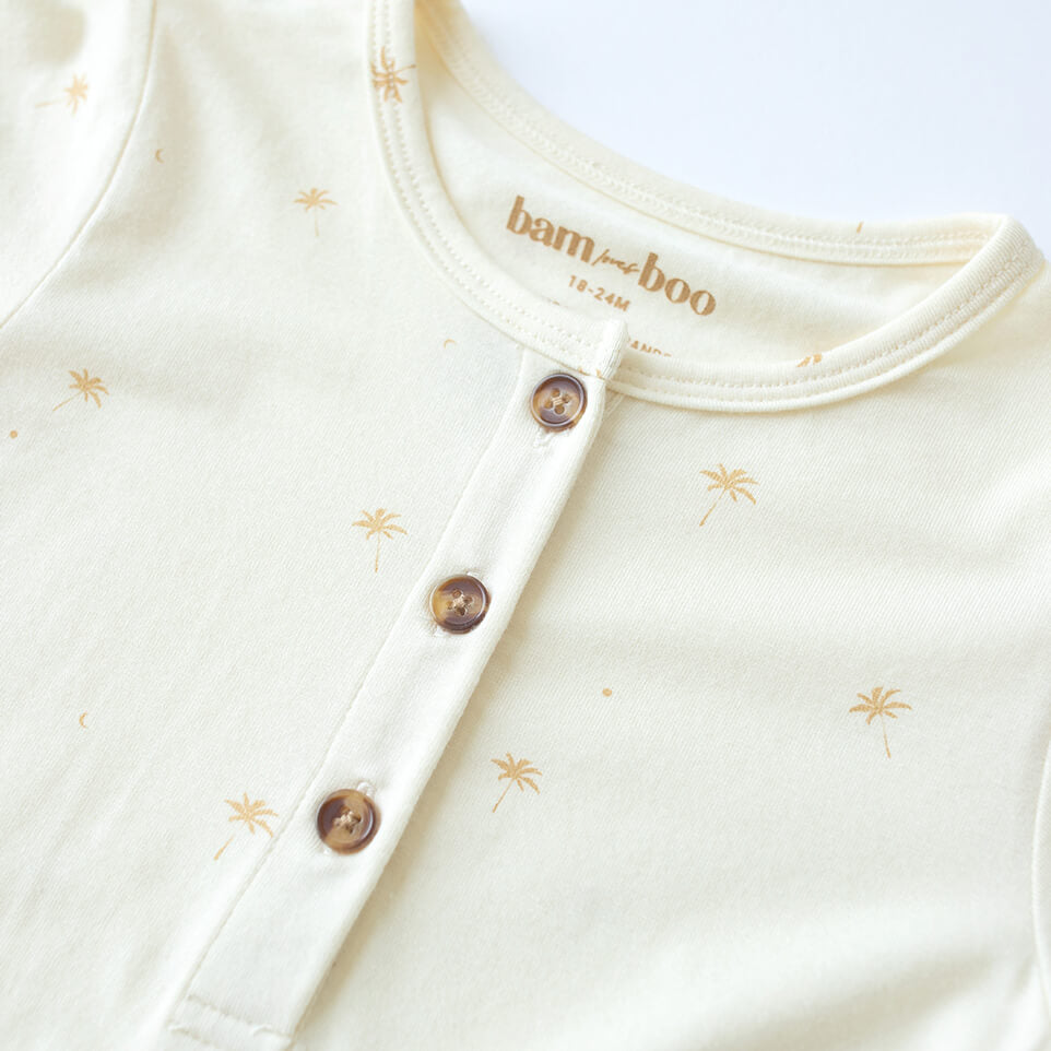 close up of bamboo cream jumpsuit with mini palm tree pattern