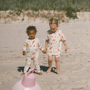 kids wearing cream Australian-summer printed bamboo onesie, and Pjs on the beach