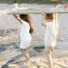 kids on beach carrying surf board wearing bam Loves Boo clothes