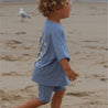 child running on beach in Blue  bike shorts and tee