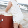 baby on beach wearing Cream baby playsuit by Bam loves Boo