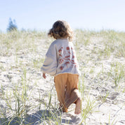 child running on beach in bam loves boo clothes