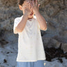 boy wearing bamboo cream tee with printed palm tress