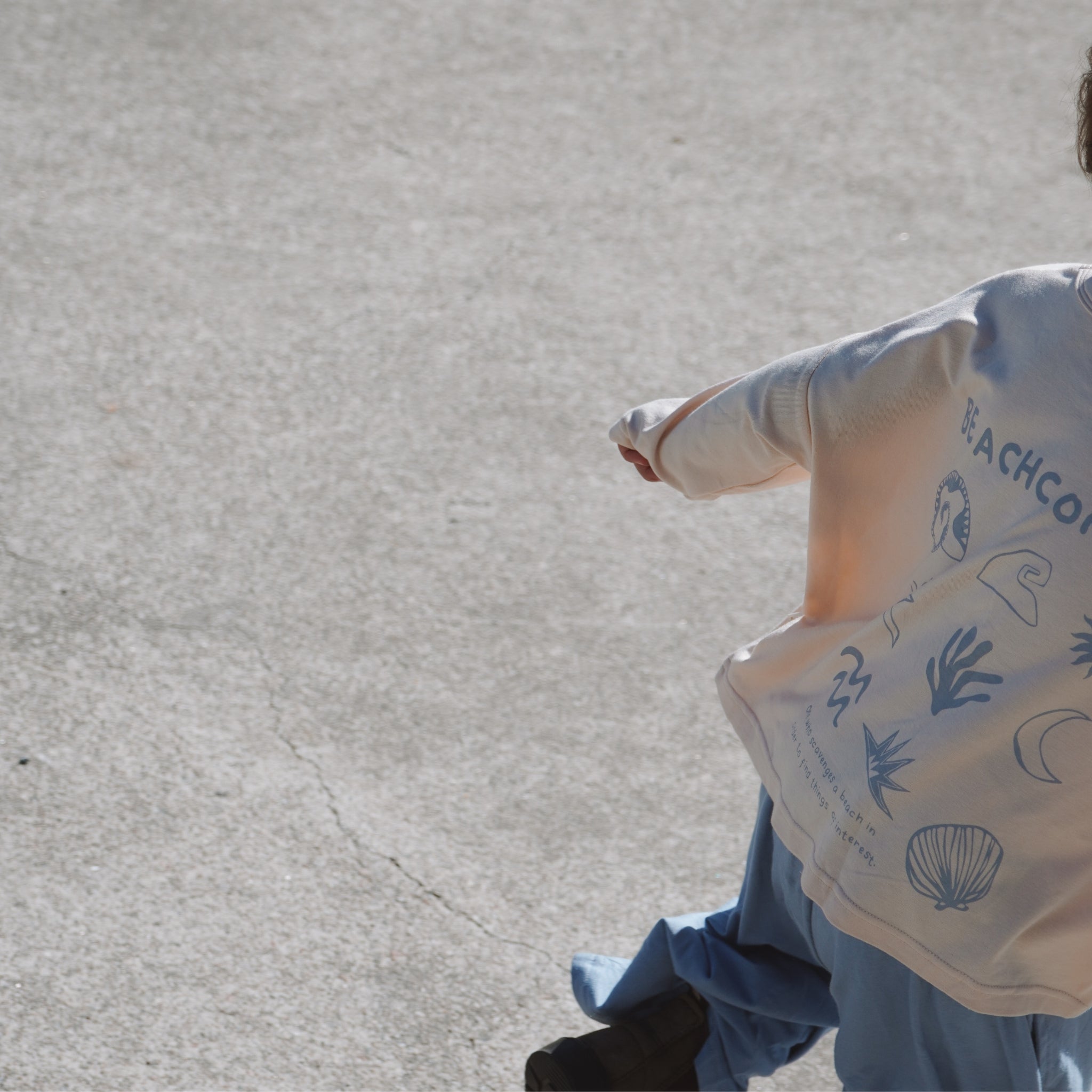 Child walking away on concrete in Beachcomber long sleeve tee, showing full back design and easy movement.