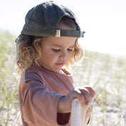 child wearing green cap backwards