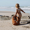 Toddler on beach carrying bam loves boo backpack