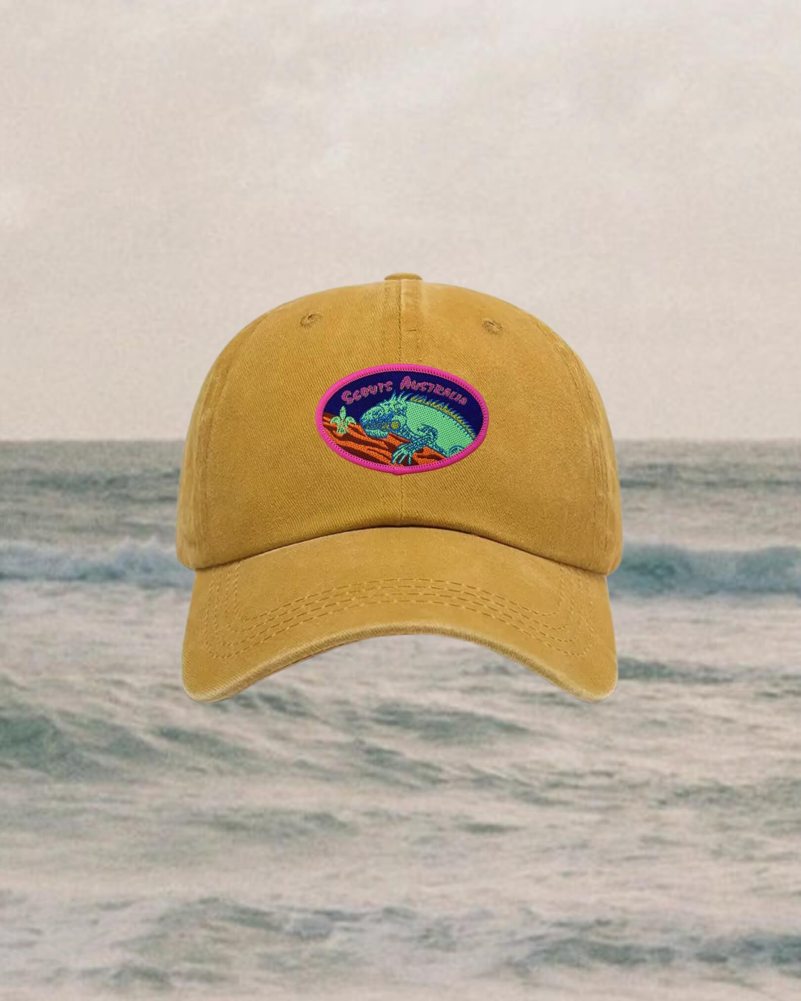 Yellow cap with a colorful patch on a beach background