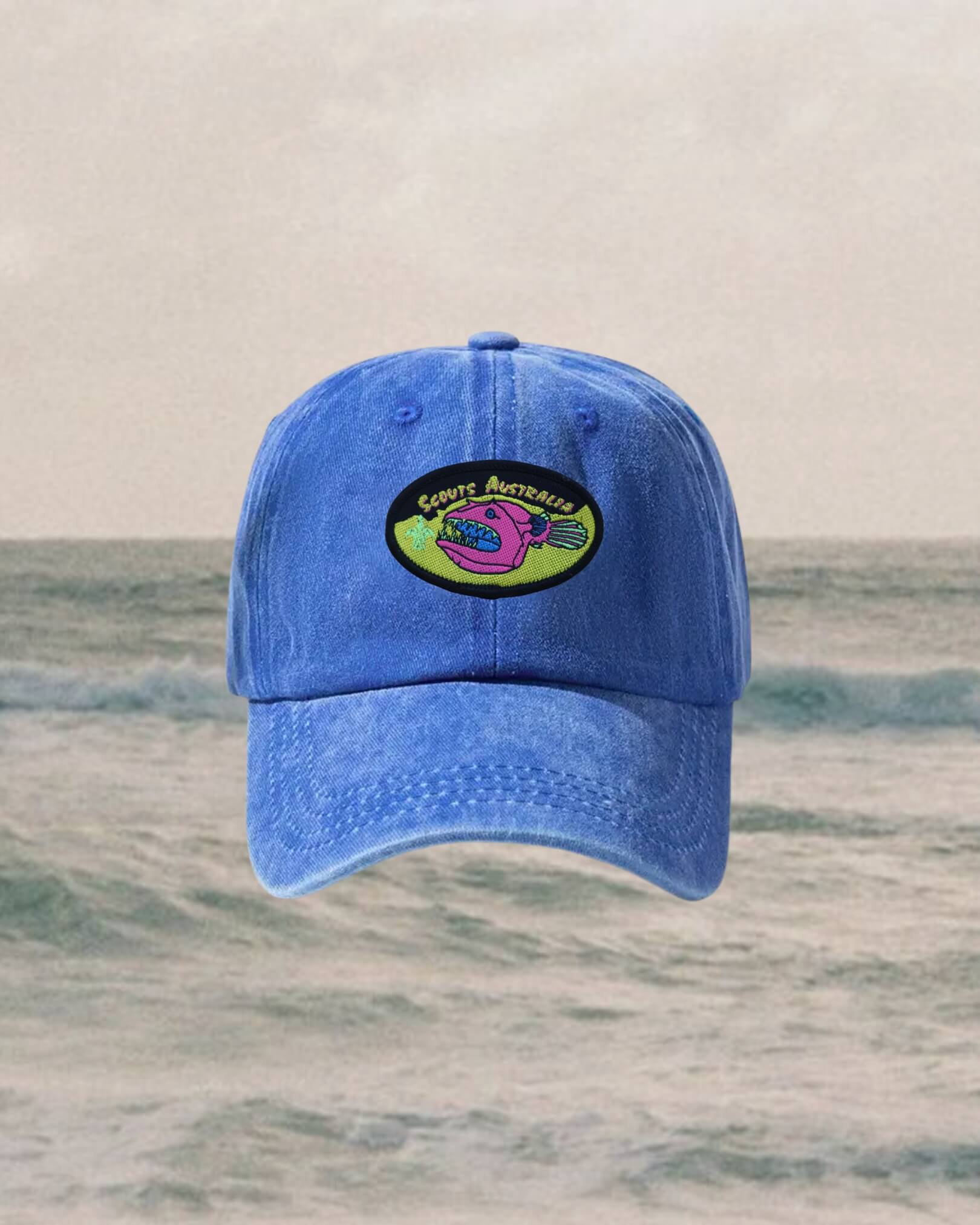 Blue cap with a 90s style logo on a ocean background