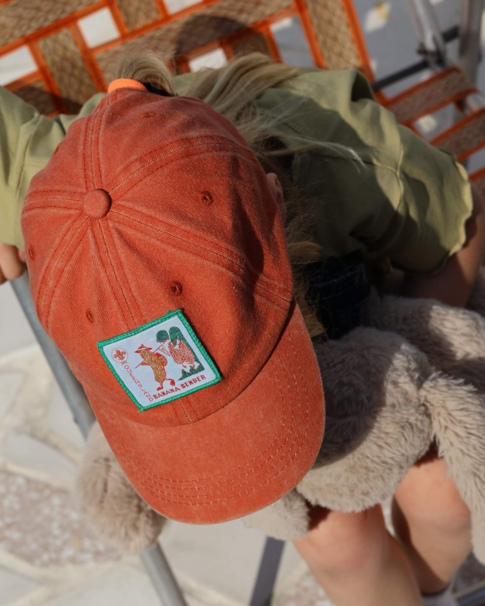 child wearing red cap with scout badge