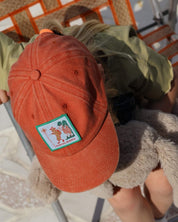 child wearing red cap with scout badge