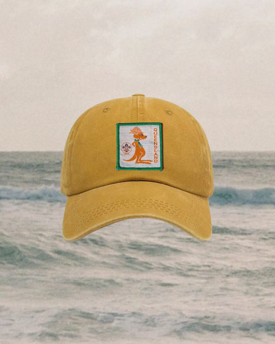 mustard Yellow cap with a logo on a ocean background