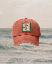 red kids cap with a badge on a background of ocean