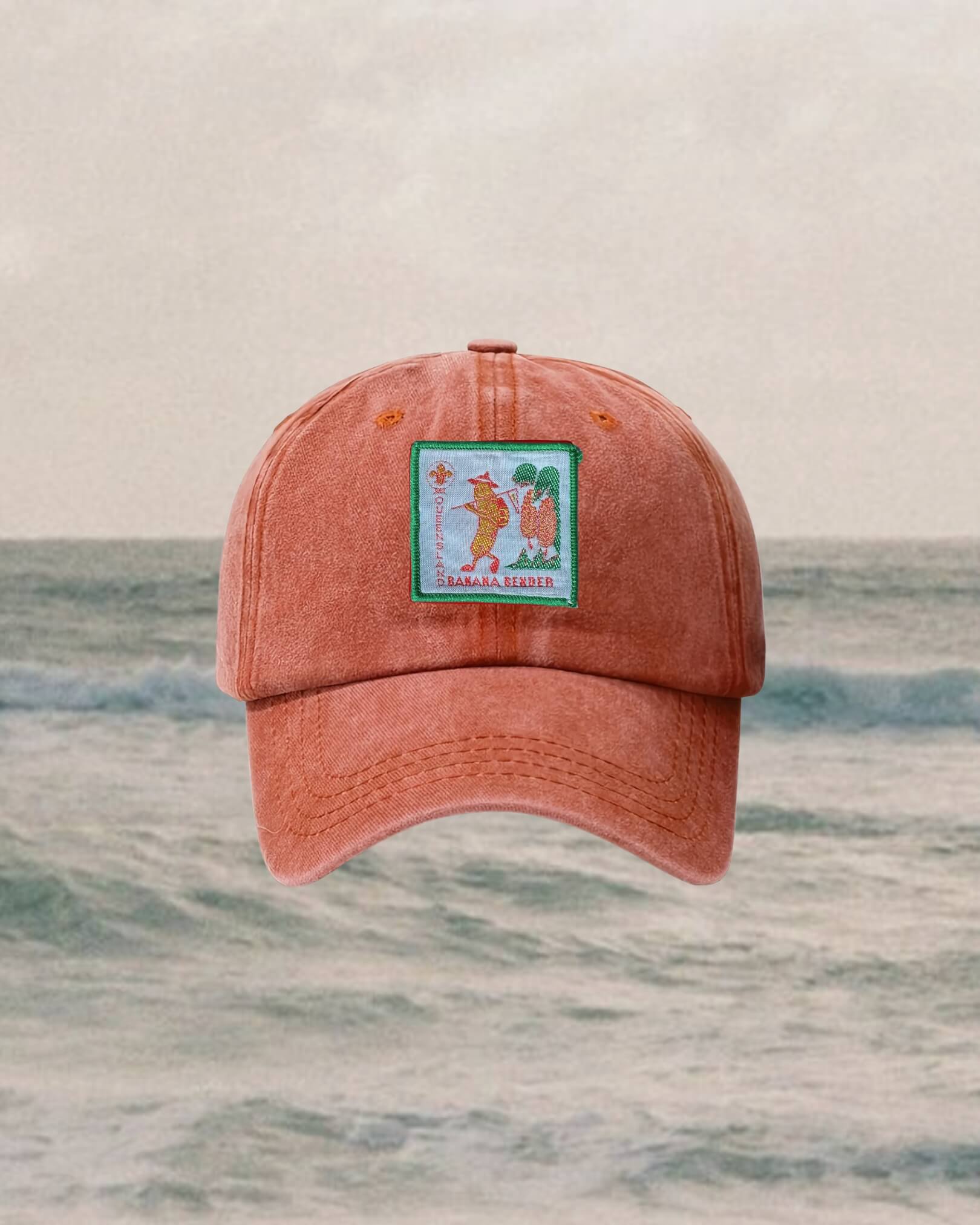 Orange cap with a logo on a beach background