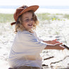 child wearing rust red cap on beach