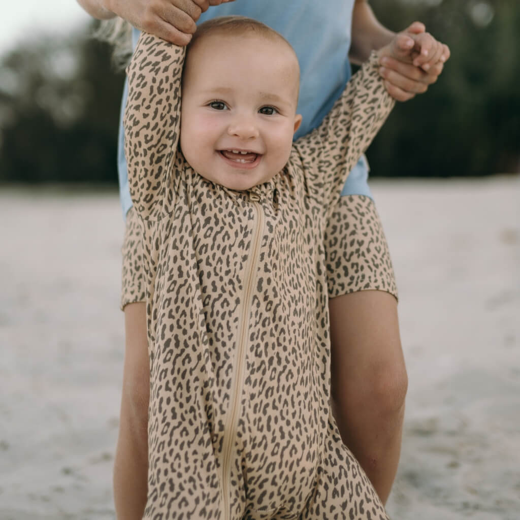 Baby wearing a bamboo leopard print onesie with zip