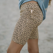 Leopard print shorts worn by a child on a beach.