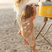 Kids in tan and blue Beachcomber print tees standing close together by Bam Loves Boo