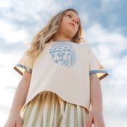 Close up of the blue Kailani shell print on a cream raglan tee by Bam Loves Boo