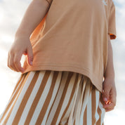 Close up of tan and cream striped shorts and an oversized tee by Bam Loves Boo