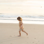Kids playing on the sand dunes in tan and cream striped shorts by Bam Loves Boo