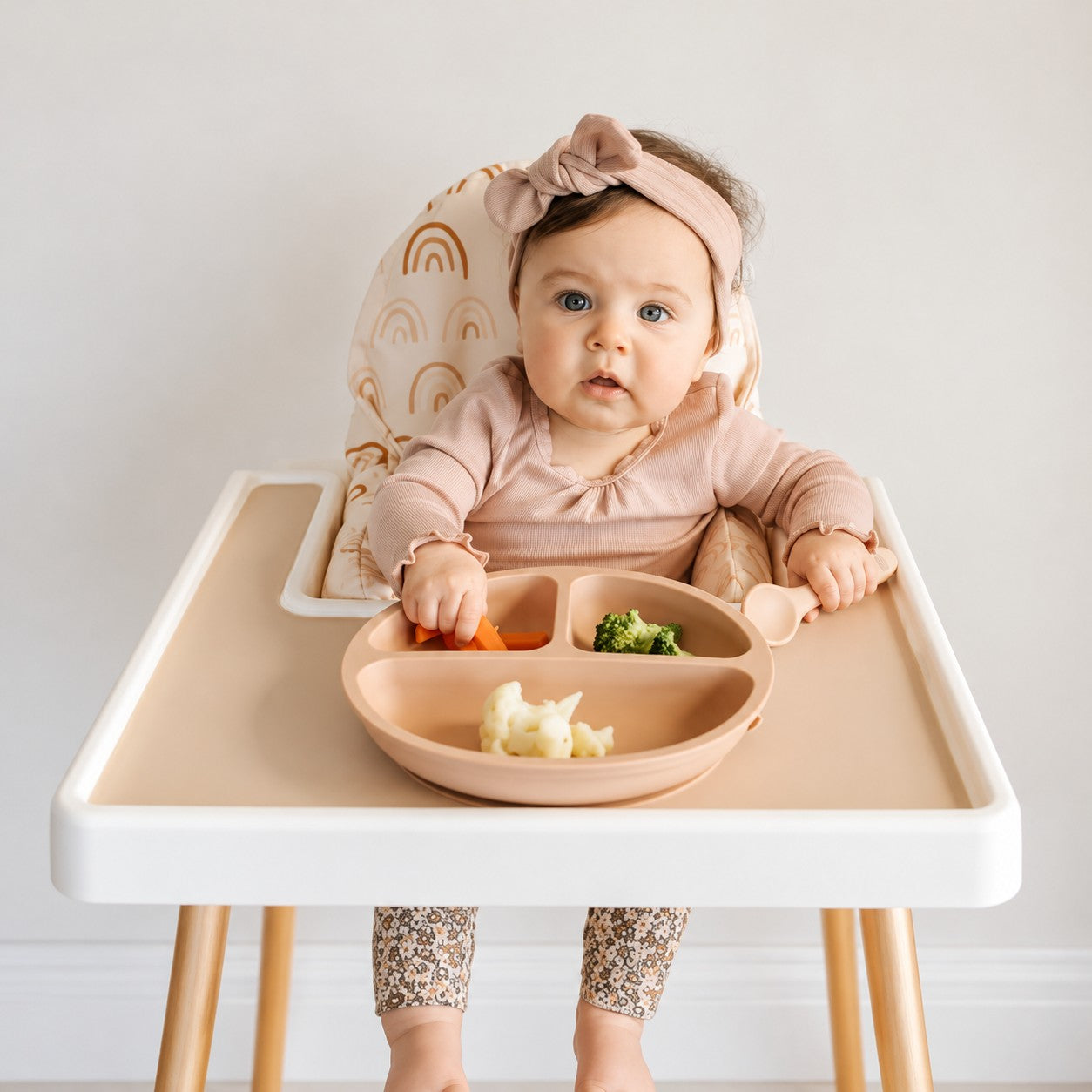 Baby eating from the Apricot silicone bento plate in a high chair