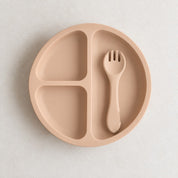 Apricot silicone bento plate with three sections and matching fork, on a soft stone background