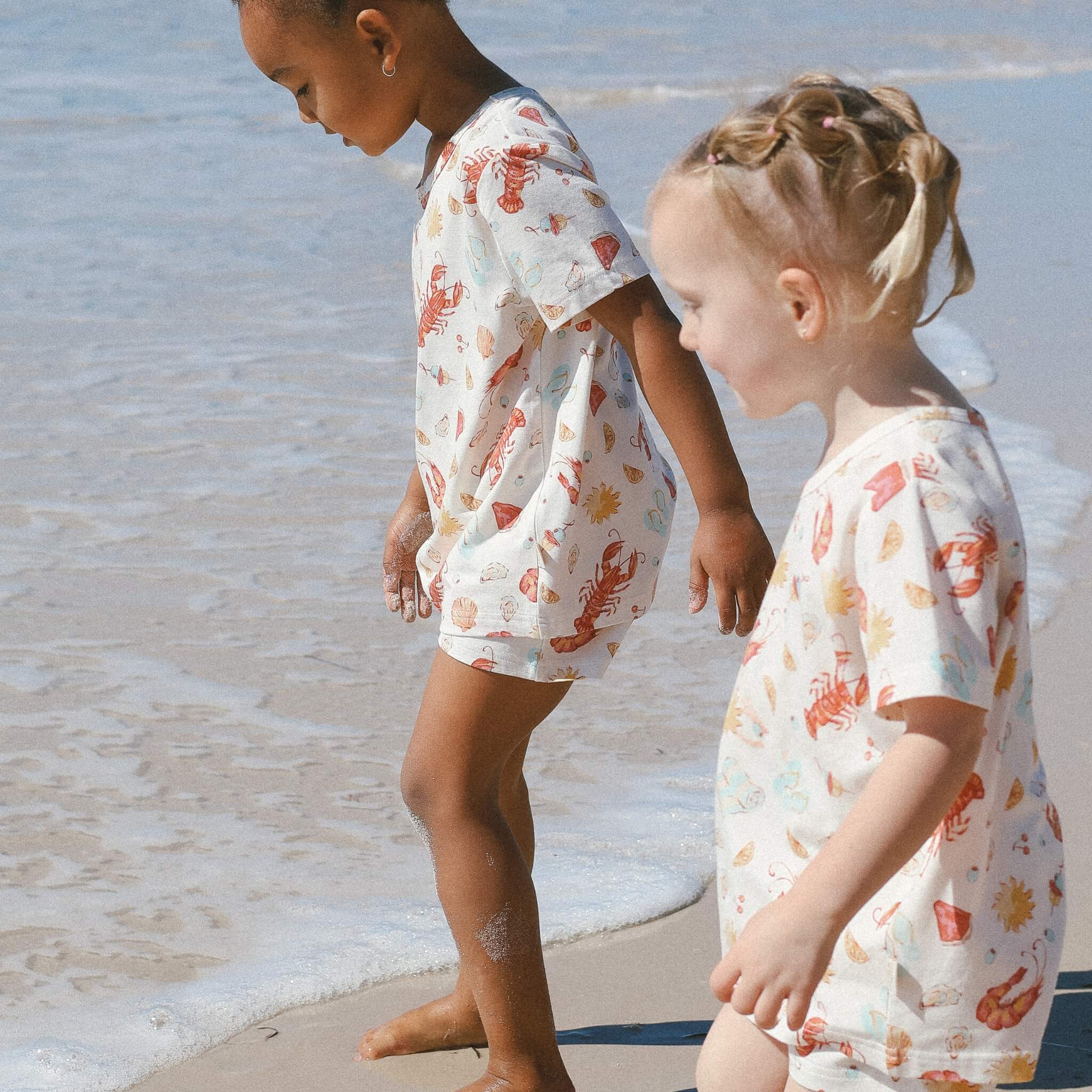kids wearing cream with Aussie summer print lobsters, prawns, shells, sun.