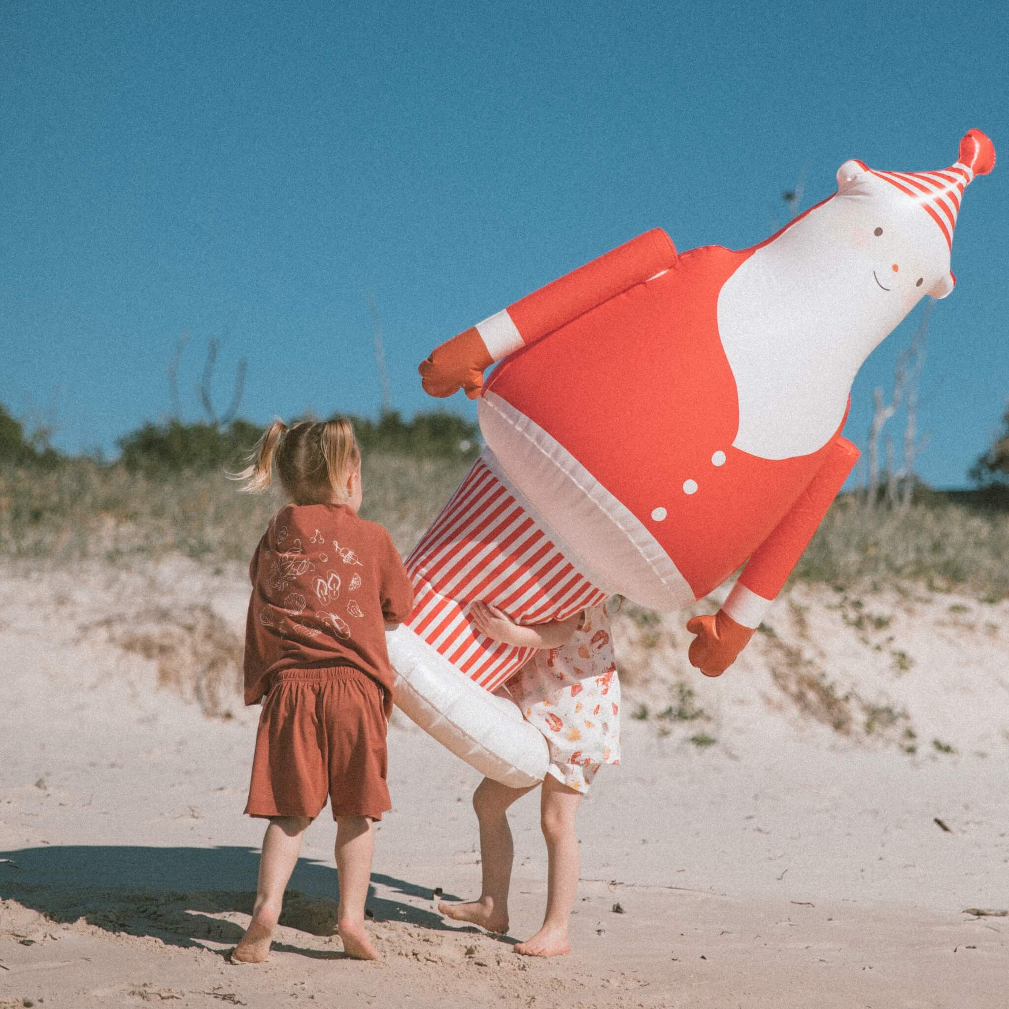 kids-playing-with-santa-inflatable-on-beach