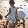 child wearing palm tree cream playsuit