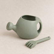 Sage silicone kids watering can and rake set, on a soft stone background