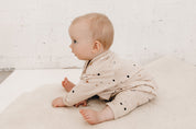 Baby wearing Terrazzo printed baby fleece beige jumpsuit  by Bam Loves Boo