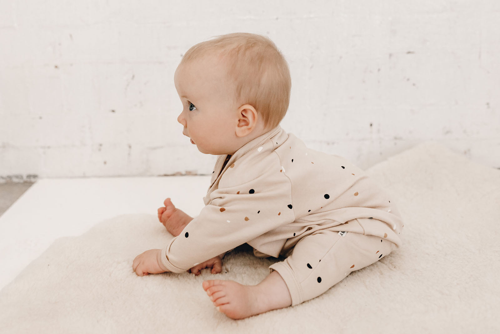 Baby wearing Terrazzo printed baby fleece beige jumpsuit  by Bam Loves Boo