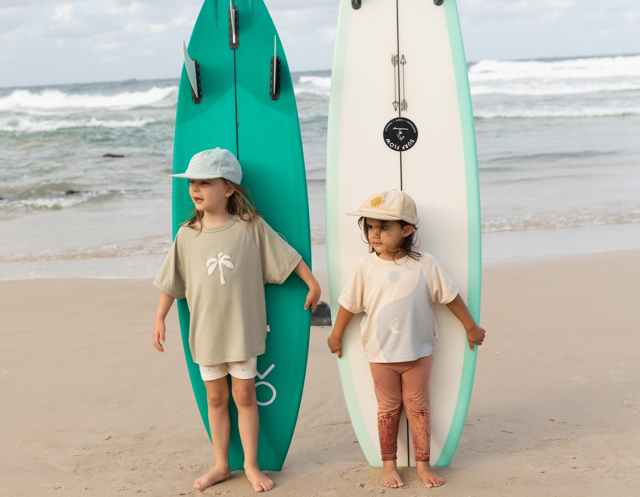 Kids wearing bamboo clothes by Bam Loves boo with surfboards